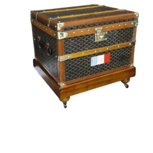 Front view of a 1920s vintage Goyard luggage trunk with casters stand, showing the chevron canvas, brass corners, and a hand-painted French flag.