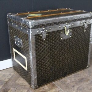 Front view of a 1930s vintage Goyard hat trunk night stand, featuring the classic chevron canvas pattern, silver steel trim, and engraved brass locks.